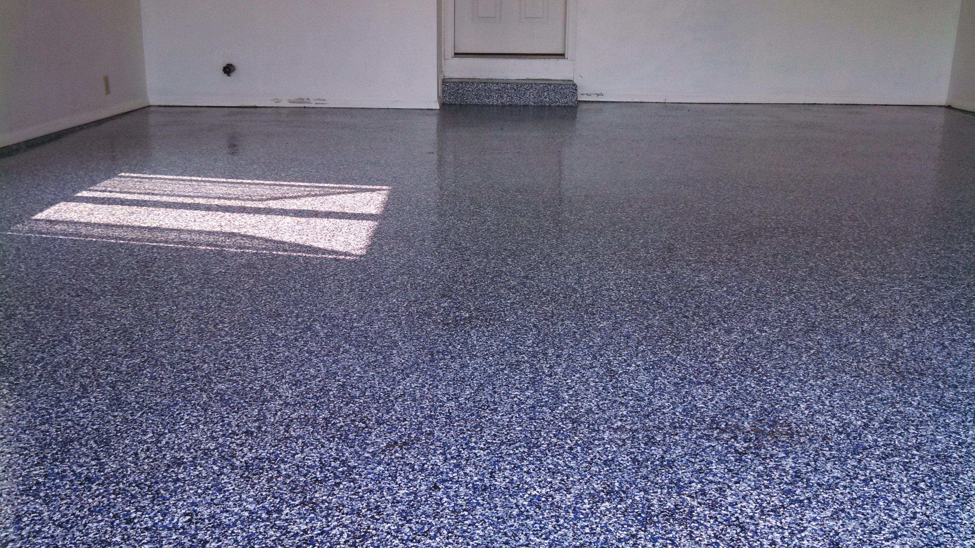 Blue and white flake epoxy garage floor with glossy finish by Expert Concrete Care
